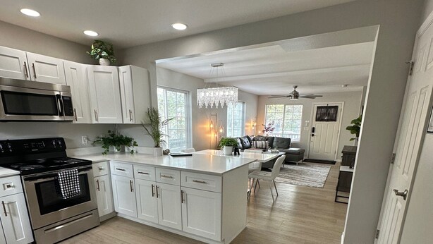 A modern kitchen with white cabinetry, stainless steel appliances, and a central island. - Townhouse on Strand...Centrally located with all new furnishings and Central AC (Missoula)