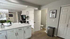 A modern kitchen with white cabinetry, a central island, and a stainless steel trash can. - Townhouse on Strand...Centrally located with all new furnishings and Central AC (Missoula)