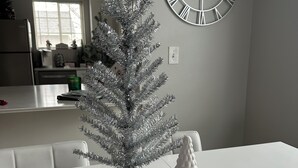 A dining table with a silver Christmas tree and miniature houses. - Townhouse on Strand...Centrally located with all new furnishings and Central AC (Missoula)