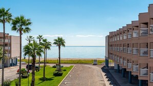 A hotel with a view of the sea, palm trees, and a parking lot. - Sunrise Beach Retreat (Corpus Christi)