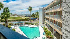 A hotel with a pool, outdoor seating, and a view of the beach. - Sunrise Beach Retreat (Corpus Christi)