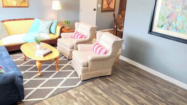 A living room with a sofa, two armchairs, a coffee table, and a rug. - Cozy Retreat with a Fenced Yard (Huber Heights)