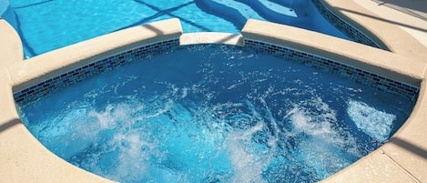 Una piscina con borde de azulejos y diseño curvo.