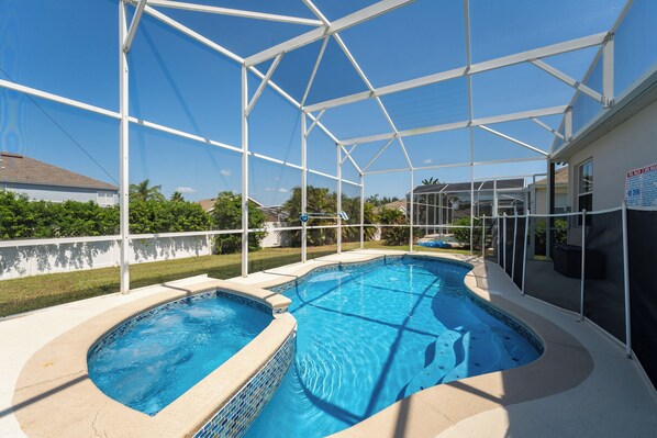 A covered swimming pool with a clear roof, surrounded by a white fence, and a view of the neighborhood. - Highlands Reserve Pool Home With Spa Close to WDW (202CPD) (Davenport)