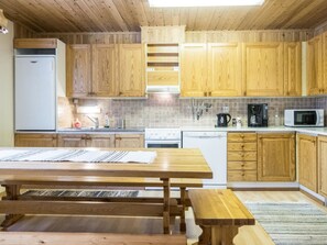 Een koelkast, een magnetron, een vaatwasser, kookgerei, borden en bestek