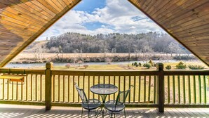 A wooden deck with a triangular roof, overlooking a river and forested hills. - Cruizin River Dreams- Riverfront, fire pit, hot tub (Todd)