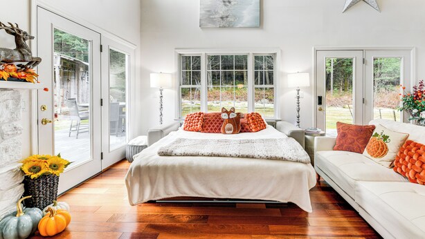 A bedroom with a large bed, two windows, a star decoration, and a view of the outdoors. - Sterling Valley Home ~ 9 Mi to Stowe Mountain! (Morristown)