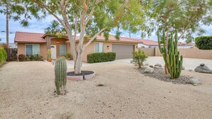 A residential house with a red-tiled roof, a gravel driveway, and a cactus in the front yard. - Desert Hot Springs Home w/ Pool & Gas Grill! (Desert Hot Springs)