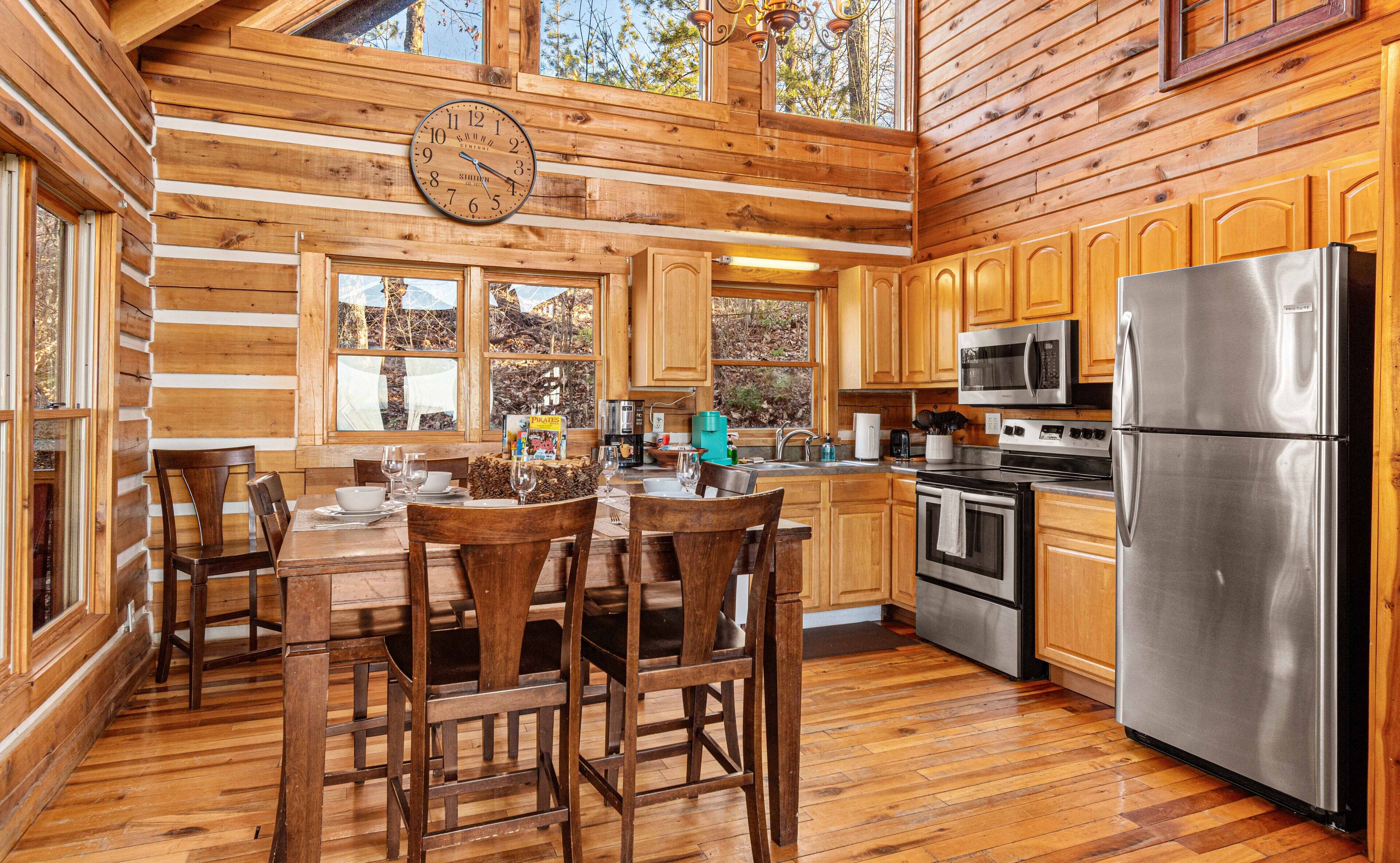 L’intérieur d’une cabane en bois comprend un coin repas, une cuisine et une horloge murale.