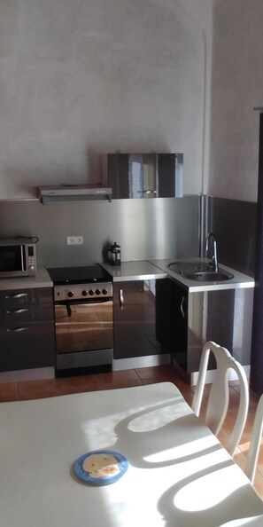 Kitchen area with microwave, stove, and sink, perfect for meal preparation.