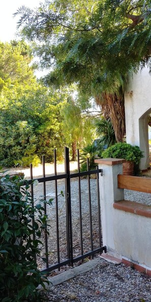 Enter a serene oasis through the secure gated entrance, surrounded by lush foliage and a tranquil garden.