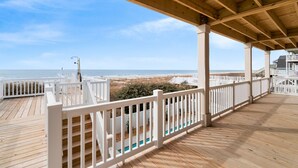A wooden deck with white railings overlooking a beach. - "Porpoise Point" - Oceanfront Home, 5 Bedrooms / 5 Bathrooms, w/ PRIVATE POOL (Holden Beach)