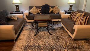 A living room with two sofas, a coffee table, patterned rug, and two lamps.