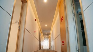 A long, narrow hotel corridor with doors on both sides, leading to rooms. - Jiangcheng Hotel (Wuhu Fangte Phase 2 Ocean Park) (Wuhu)