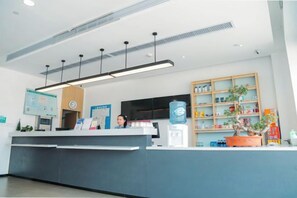 A reception desk with a digital screen, a water dispenser, and a potted plant. - Jiangcheng Hotel (Wuhu Fangte Phase 2 Ocean Park) (Wuhu)