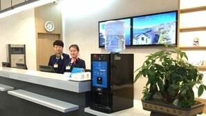A reception area with a digital kiosk, a water dispenser, and a potted plant. - Jiangcheng Hotel (Wuhu Fangte Phase 2 Ocean Park) (Wuhu)