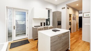 Una cocina moderna con una isla central, un comedor y un horno empotrado.
