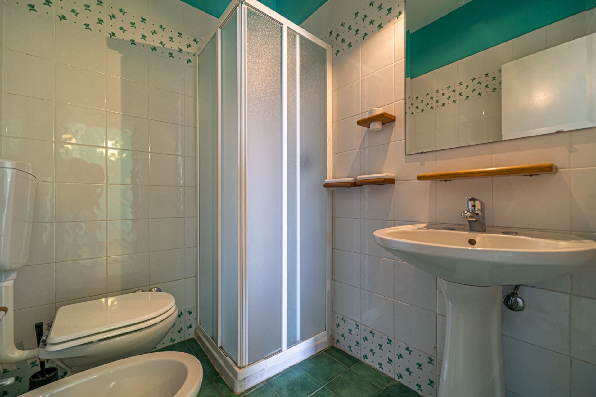 Ein Badezimmer mit Toilette, Bidet, Dusche und Waschbecken.