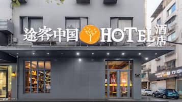 Un hôtel doté d’une façade moderne, de grandes fenêtres et d’une enseigne indiquant qu’il s’agit d’un hôtel.