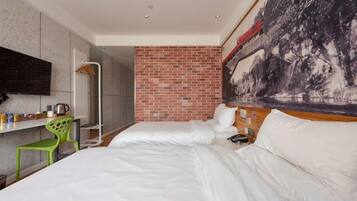 Une chambre d’hôtel avec un lit, un bureau et une chaise, un grand tableau au mur et un mur décoratif en briques apparentes.