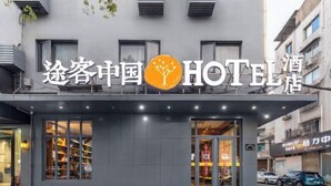 A hotel with a modern facade, large windows, and a visible entrance. - Tuke China Hotel (Pingyang Aojiang Pearl Plaza Store) (Pingyang)