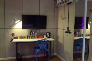 Habitación con escritorio, silla, televisor y espejo.