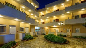 A multi-story hotel with a central courtyard, stone flooring, and balconies with railings. - Hotel Fotini (Kalamata)