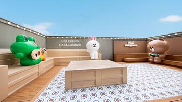 A children's play area with a large white rabbit mascot, a green frog mascot, and a brown bear mascot.