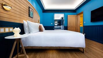 A modern bedroom with a large bed, a bedside table, and a wall-mounted TV.