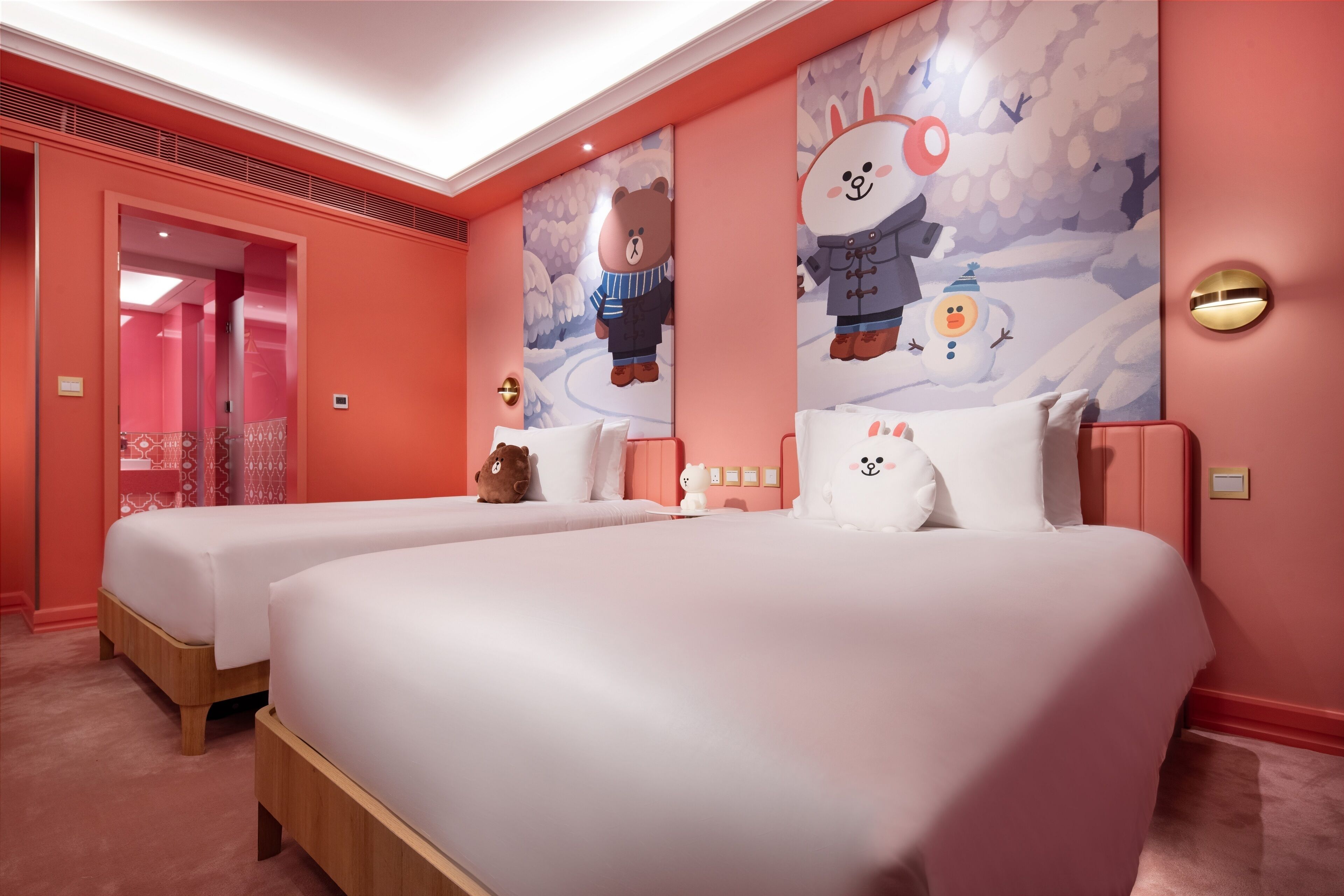 A hotel room with two beds, a large wall mural, and a red accent wall.