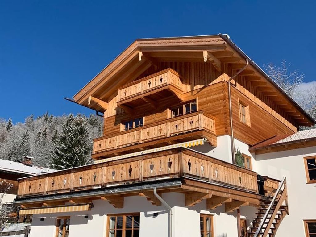Una cabaña de madera de varios pisos con balcones y una escalera.