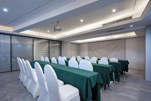 A conference room with a long table, white chairs, and a projector. - Tingxi International Hotel (Changsha County)