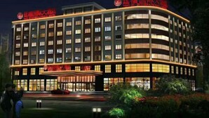 A multi-story hotel with a curved facade, illuminated windows, and signage in red. - Tingxi International Hotel (Changsha County)