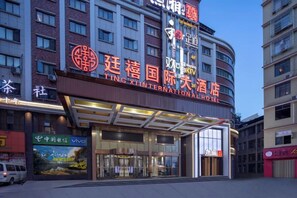 A hotel with a prominent sign, a covered entrance, and a modern facade. - Tingxi International Hotel (Changsha County)