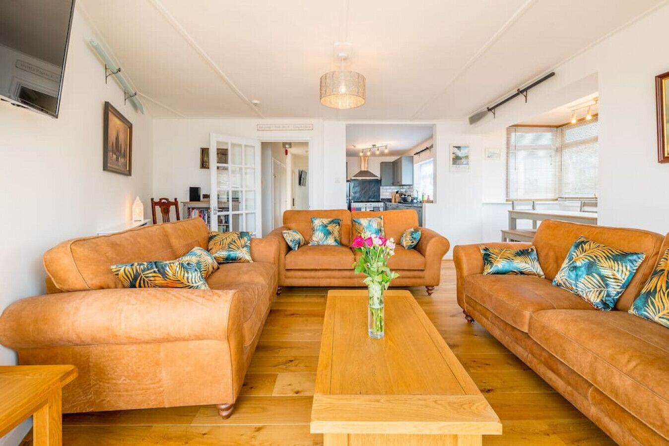 A living room with two sofas, a coffee table, and a vase of flowers.