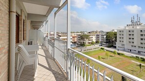 A balcony with a view of a residential area, including buildings and a park. - Apartment "Ca Laurana 42" with Sea View, Air Conditioning and Terrace (Bibione)
