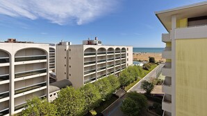 Ett hotell med flera våningar, en pool, utsikt över stranden och en parkeringsplats.