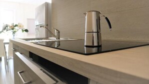 Een moderne keuken met een roestvrijstalen waterkoker, een strak aanrecht en een minimalistisch ontwerp.