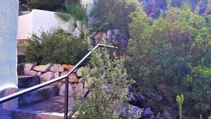A staircase with a metal handrail, surrounded by greenery and rocks. - Costa Blanca - Villa with sea views, A/C, WiFi and pool heating in an exclusive location (Monte Pego, Alicante)