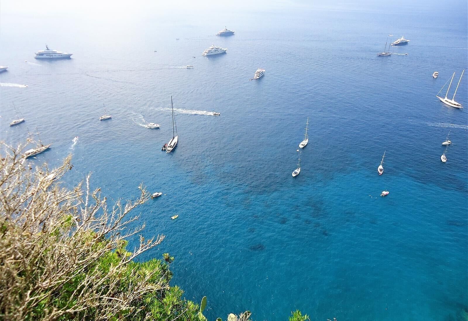 Vista costera con varios barcos y yates en el agua.