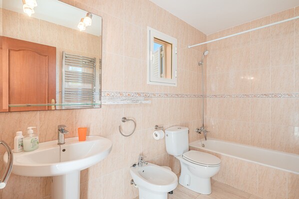 Ein Badezimmer mit Waschbecken, Bidet, Toilette und Badewanne.