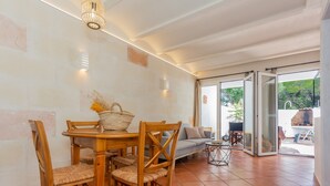 Un coin repas avec une table et des chaises en bois, un panier et un canapé.