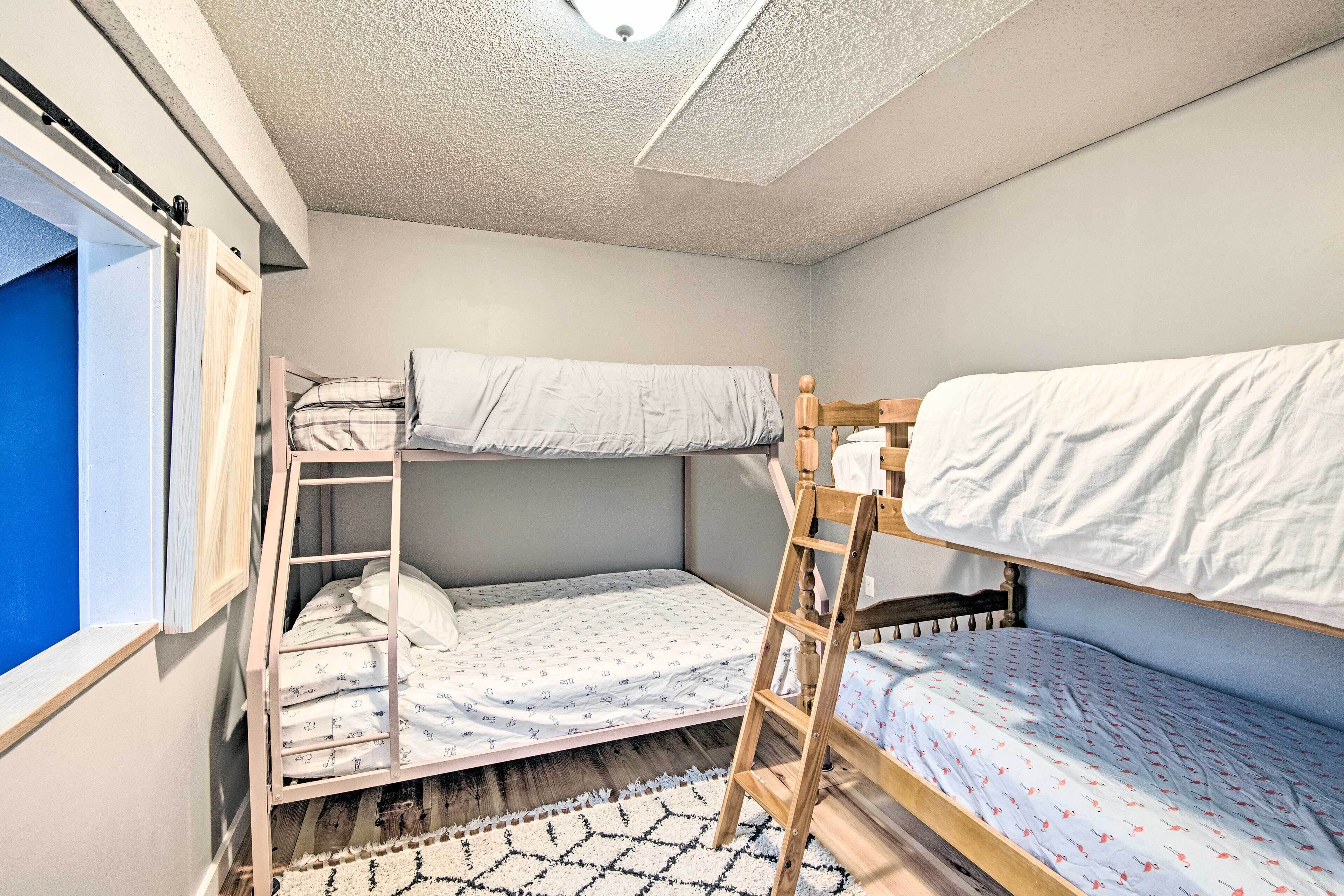 Een slaapzaal met stapelbedden, een raam en een plafondlamp.