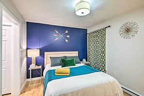 A bedroom with a bed, a nightstand, a lamp, and decorative wall art. - Near Newfound Lake: Plymouth Condo w/ Fireplace! (Plymouth)