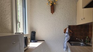 A compact kitchen with a coffee maker, a hanging towel, and a tiled backsplash. - Bright 1-bedroom apartment, south balcony, for 6, in Pra Loup 1500 (Pra-Loup)