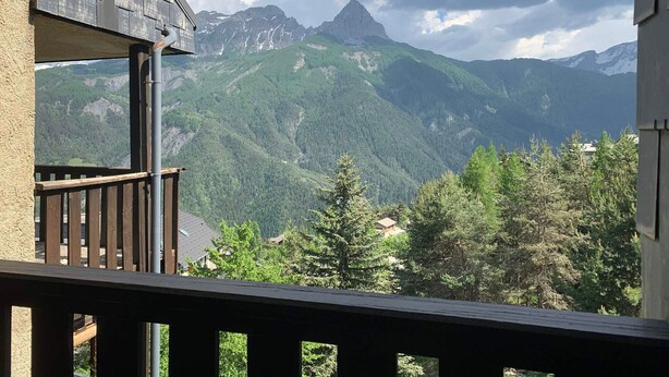 A balcony with a view of a mountain range and forested area. - Bright 1-bedroom apartment, south balcony, for 6, in Pra Loup 1500 (Pra-Loup)
