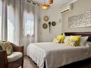 A bedroom with a bed, a chair, a hanging light fixture, and wall decorations. - VERACRUZ villa individual con gran piscina (Miami Playa)