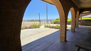 Ein überdachter Patio-Bereich mit Blick auf Strand und Meer.