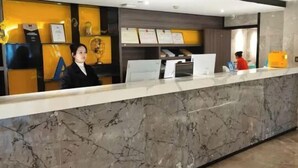 A reception desk with a marble counter, framed certificates, and a computer. - Maple, Longyan, Wanda Plaza (Longyan)