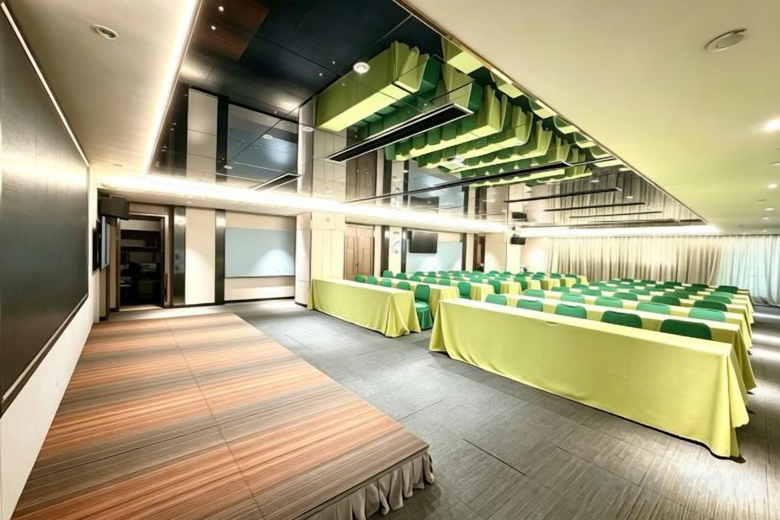 A conference room with tiered seating, a stage, and a modern design.